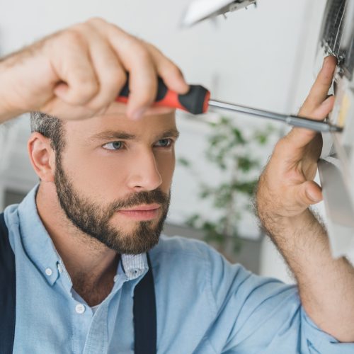 repairman-fixing-air-conditioner-with-screwdriver-at-home.jpg